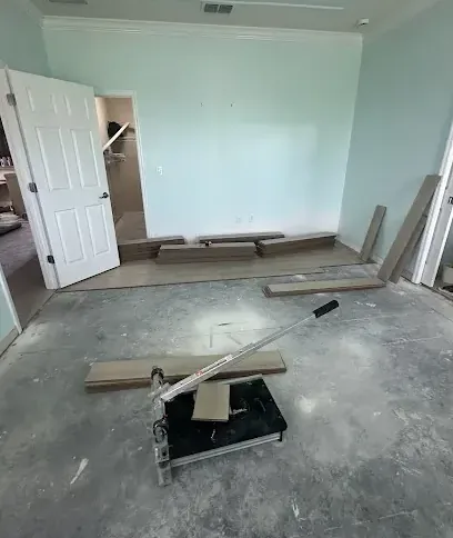 Flooring pulled up to expose a wet concrete slab inside a home