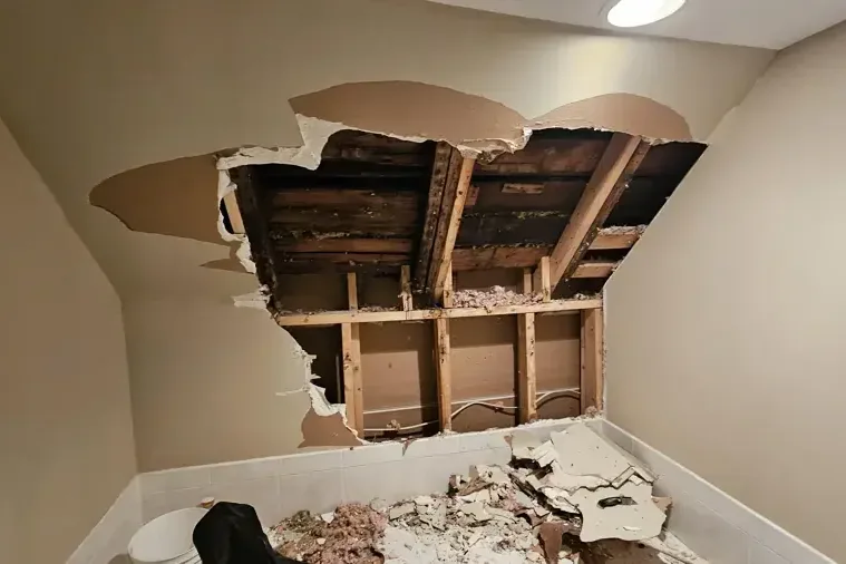 Collapsed ceiling drywall after a leak, with the joists exposed