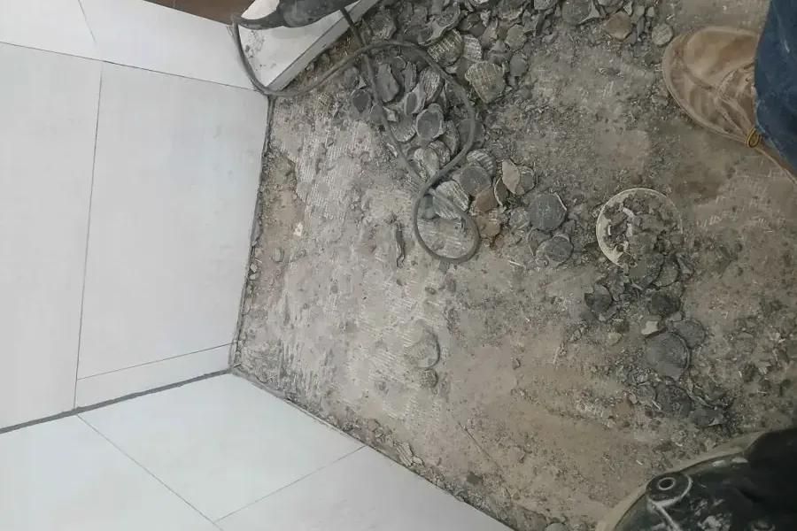 Tile cut back and the concrete slab broken open to reach a leaking pipe underneath